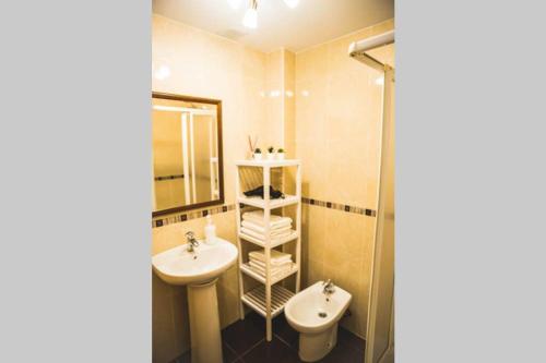 a bathroom with a sink and a toilet and a mirror at Apartamento con vistas al mar en Pedregalejo playa in Málaga