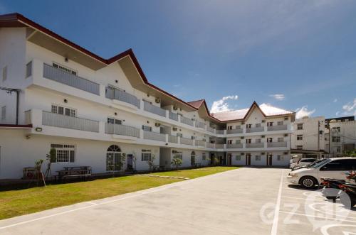 a large white building with cars parked in the driveway at Mu Yu B&B in Hengchun South Gate