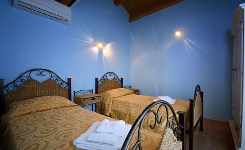 サンタンティーオコにあるB&B Il Cenerinoのベッドルーム1室(ベッド2台、壁に照明2つ付)