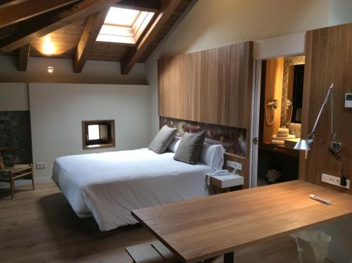 a bedroom with a large white bed and a table at Palacio de Yrisarri by IrriSarri Land in Igantzi