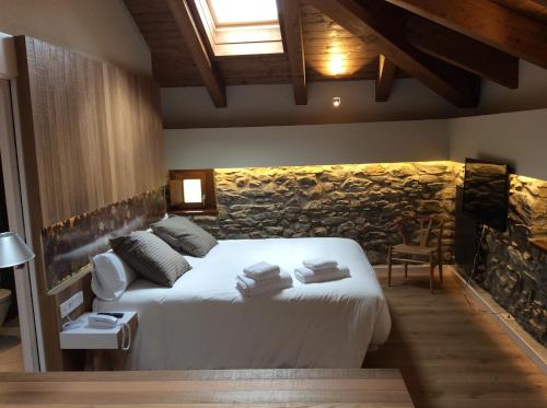 a bedroom with a bed and a stone wall at Palacio de Yrisarri by IrriSarri Land in Igantzi
