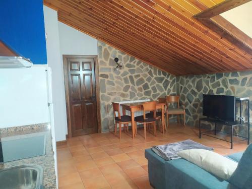 a living room with a table and a tv at Tejadillos - Apartamentos El Cabo in Las Majadas