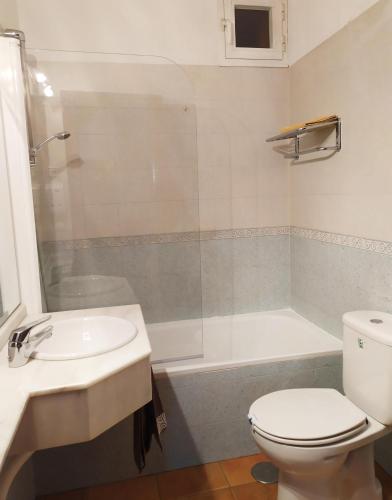 a bathroom with a toilet and a sink and a tub at Tejadillos - Apartamentos El Cabo in Las Majadas