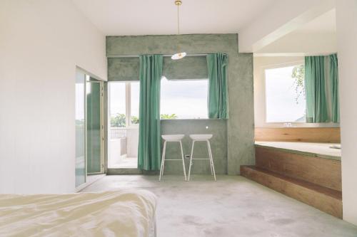 a bedroom with a bed and a tub and a sink at OwlStay Jiufen Green Ray - 故事所 山中夢遊 九份綠光 in Jiufen