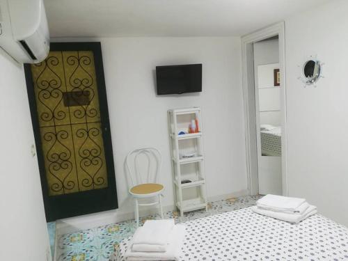 a white room with a bed and a chair at VILLA ISCLA maison d'hôtes in Ischia