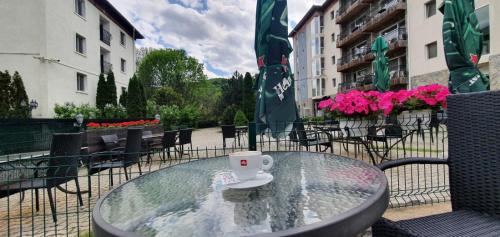 a glass table with a coffee cup on top of it at Hotel Monteoru in Sărata-Monteoru