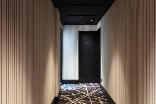 a hallway with a black door and a tile floor at Casa Elliot Hotel in Barcelona