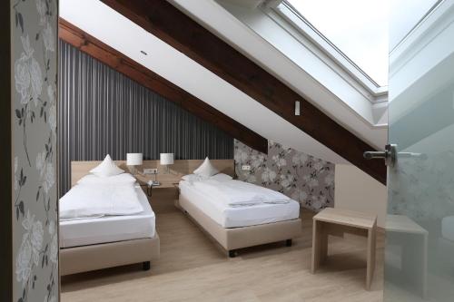 a bedroom with two beds and a skylight at Hotel-Restaurant Vogthof in Aalen