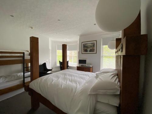 a bedroom with a bed with white sheets and a desk at Rooms36 in Keswick