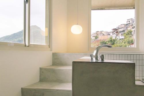a bathroom with a sink and a window at OwlStay Jiufen Green Ray - 故事所 山中夢遊 九份綠光 in Jiufen