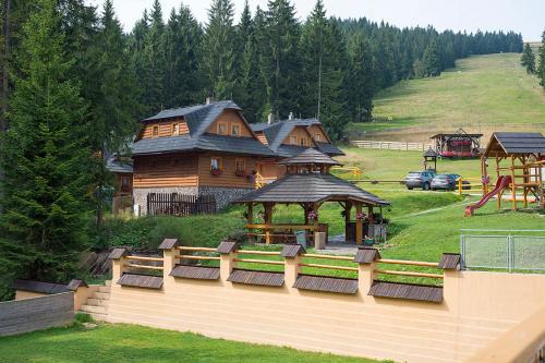 a large wooden building with a gazebo in a park at Koliba u Kuba a rekreačné domy in Hruštín