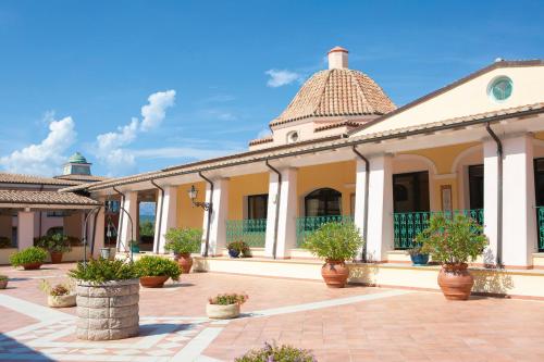 an old building with potted plants in a courtyard at Club Hotel Marina Beach in Orosei