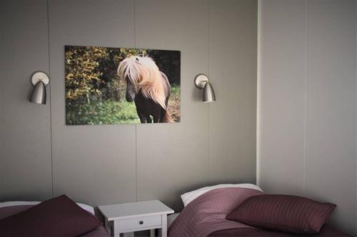 a living room with a horse picture on the wall at Strýta Apartment 3 in Ölfus