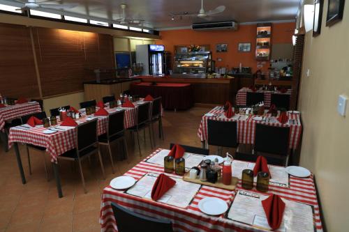 a restaurant with red and white tables and chairs at Huon Gulf Hotel in Lae