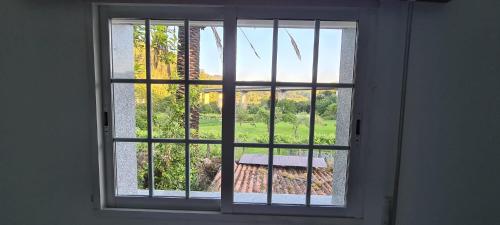 a window with a view of a garden at A Taberna de Gundián in Vedra