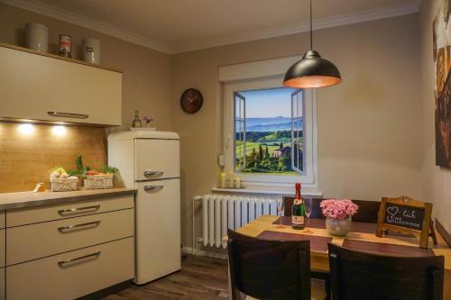 a kitchen with a table and a refrigerator and a window at Ferienwohnung Kirchblick, für Familien, Freunde, keine Monteure in Gräfenhainichen