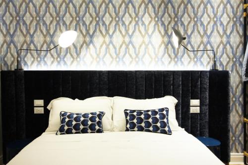 a bedroom with a black and white bed with pillows at Le Porte Blu in Trieste