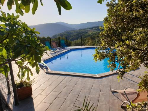 une piscine avec des chaises et des montagnes en arrière-plan dans l'établissement Studio charmant avec piscine partagée à Draguignan, 42 m², à Draguignan