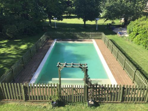 an empty swimming pool with a wooden fence at Le Logis de Limalonges in Limalonges