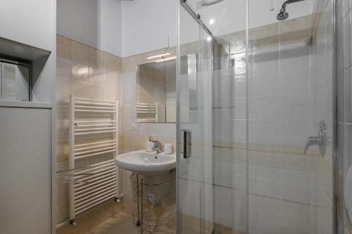 a white bathroom with a sink and a shower at San Bernardino 8 - Immobili e Soluzioni Rent in Bergamo