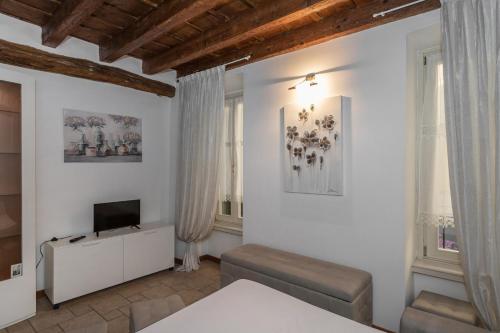 a living room with white walls and a television at San Bernardino 8 - Immobili e Soluzioni Rent in Bergamo