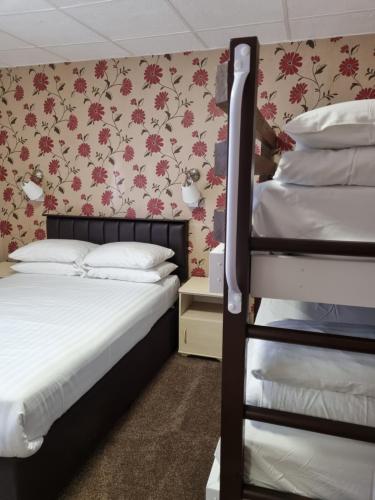 a bedroom with two bunk beds and a wall with flowers at The Beechfield Hotel in Blackpool