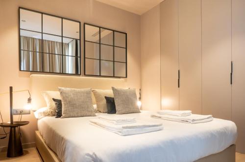 une chambre avec un grand lit blanc avec un miroir dans l'établissement Valencia Luxury - Sea Port I, à Valence