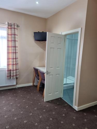a room with a door and a table and a mirror at The Beechfield Hotel in Blackpool
