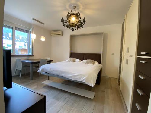 a bedroom with a bed and a table and a chandelier at Apartment ALBA in Bovec