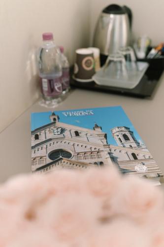 a book on a table with a picture of a building at Hotel Giulietta e Romeo ***S in Verona