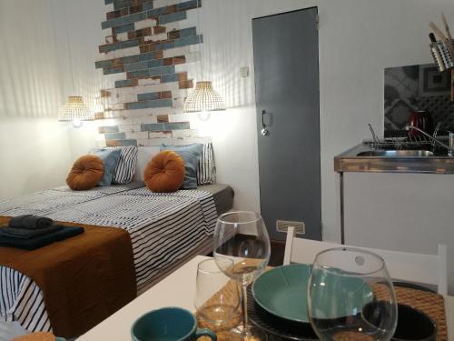 a room with a bed and two wine glasses on a table at The Portuguese Element in Faro