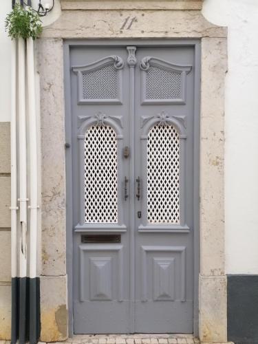 a gray door on the side of a building at The Portuguese Element in Faro