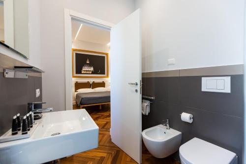 une salle de bains avec lavabo et toilettes et un lit dans l'établissement Amazing Vittoriano, à Rome