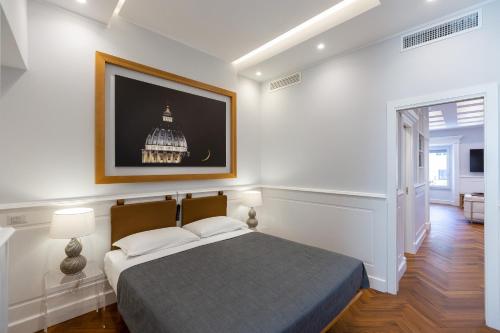 une chambre avec un lit et un tableau au mur dans l'établissement Amazing Vittoriano, à Rome
