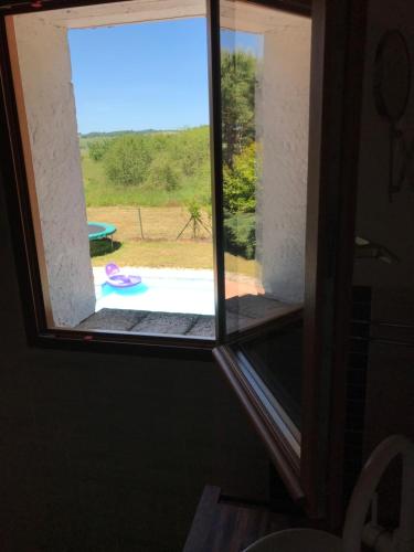 an open window with a view of a pool at gîte de Fontjalabert en campagne tout confort in Lisle-sur-Tarn