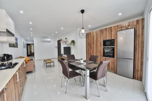 a kitchen and dining room with a table and chairs at Apartment 5 Ashville Court in Marsalforn