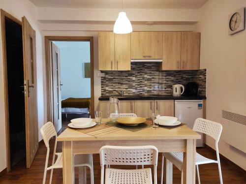 a kitchen with a wooden table with chairs and a dining room at Apartament Piaskowy NR A5 (3-5 os.) in Rowy