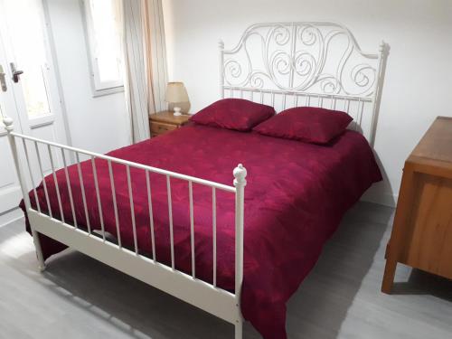 ラ・ロシェルにある19 Rue Verdièreの白いベッド(赤い枕付)が備わるベッドルームです。