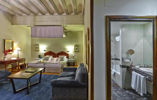 um quarto de hotel com uma cama e uma sala de estar em Parador de Zamora em Zamora