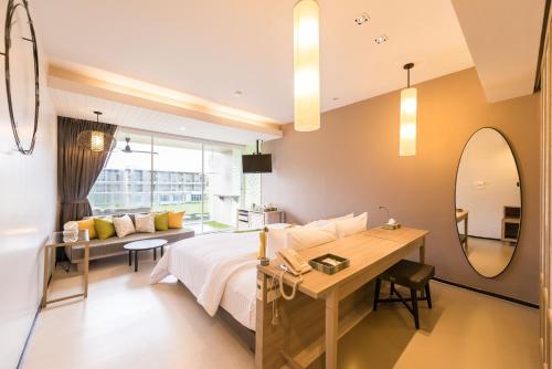a bedroom with a bed and a desk and a mirror at The Sands Khao Lak by Katathani - SHA Extra Plus in Khao Lak