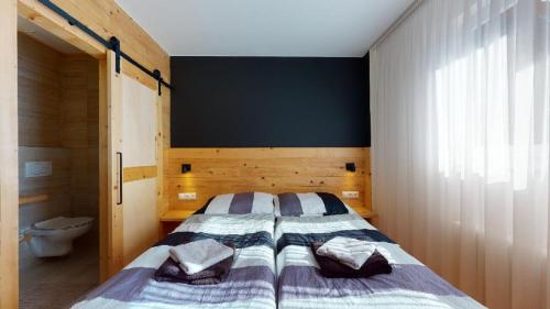 a bedroom with a large bed and a toilet at Penzion Sabina in Vernár