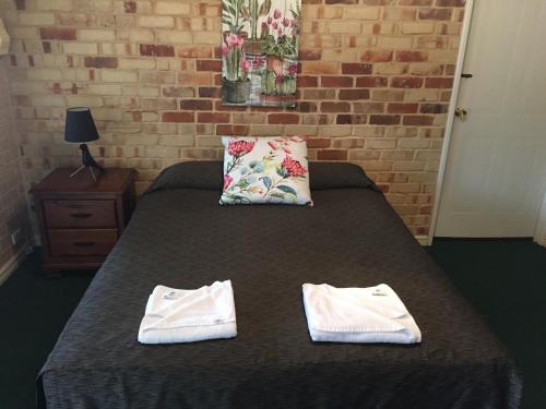 Tempat tidur dalam kamar di Travellers Rest Motel