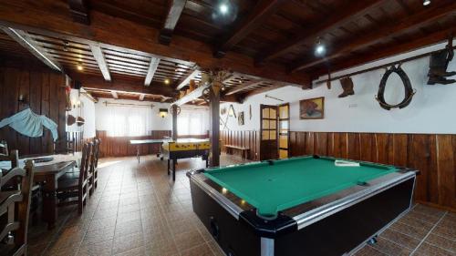 a room with a pool table and a dining room at Penzion Sabina in Vernár