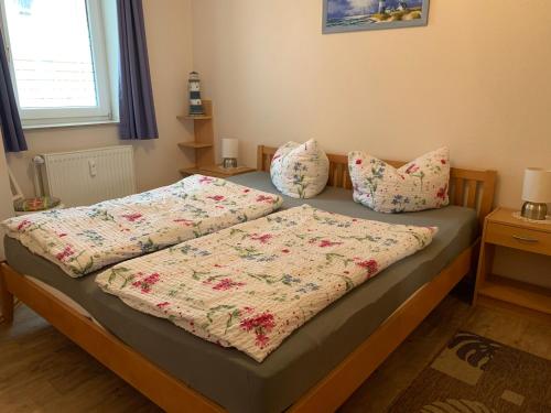 ein Schlafzimmer mit einem Bett mit zwei Kissen darauf in der Unterkunft Ferienwohnung Dieta in Norderney