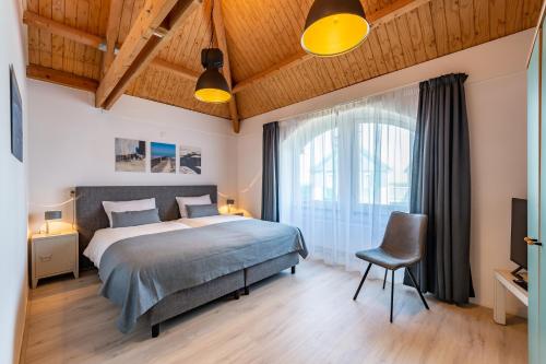 ein Schlafzimmer mit einem großen Bett und einem Stuhl in der Unterkunft Grasse 148 - Kustpark Village Scaldia in Hoofdplaat