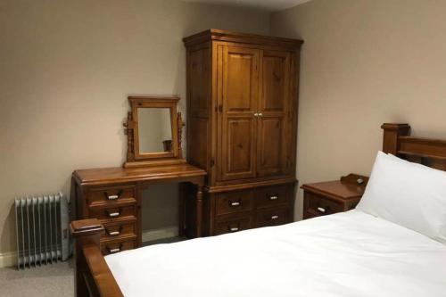 a bedroom with a bed and a dresser and a mirror at York - The Burton Stone - with parking in York