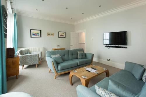 a living room with a blue couch and a table at Seaside Retreat in North Bay - with parking in Scarborough