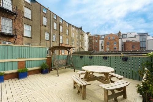 a patio with a table and benches and buildings at Seaside Retreat in North Bay - with parking in Scarborough