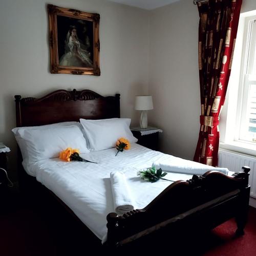 Un dormitorio con una cama con flores. en Fennessy's Hotel en Clonmel