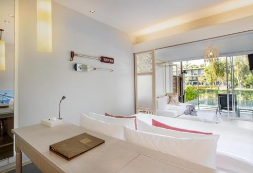 a living room with a white couch and a table at The Sands Khao Lak by Katathani - SHA Extra Plus in Khao Lak